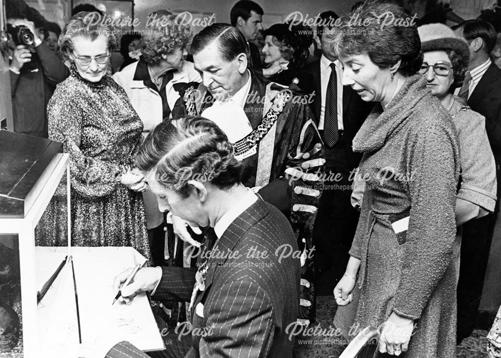 Prince Charles signs the visitors book at Warwick House