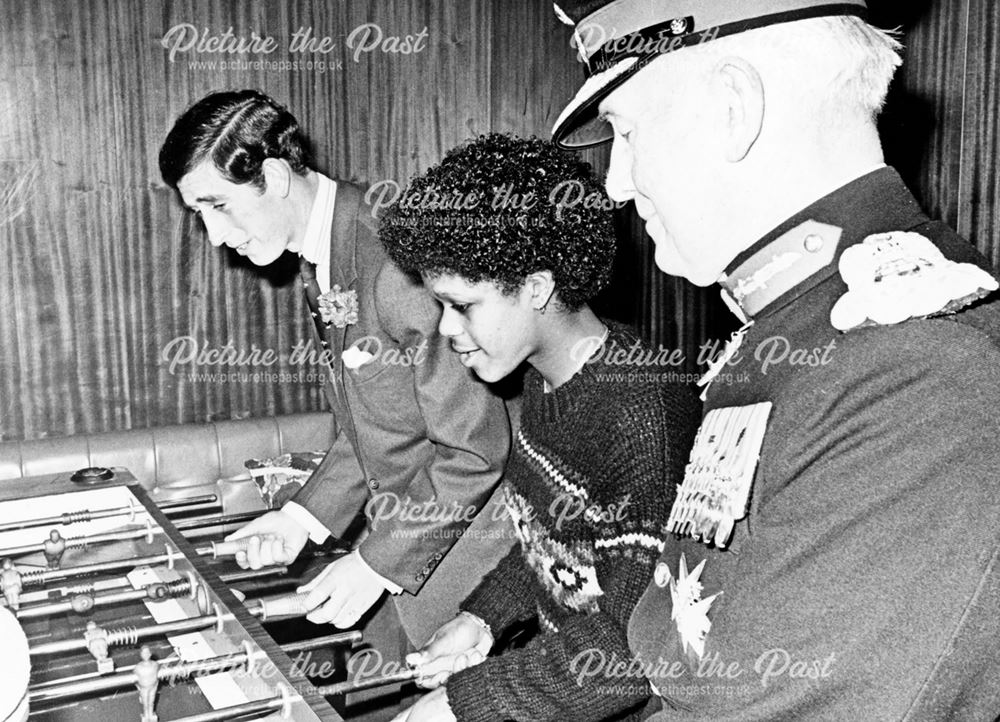 Prince Charles plays table football with community members at the Madeley Centre