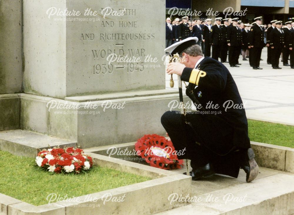 A Royal Naval Rear Admiral laying a wreath at the war memorial during a Royal Navy and Royal Marines