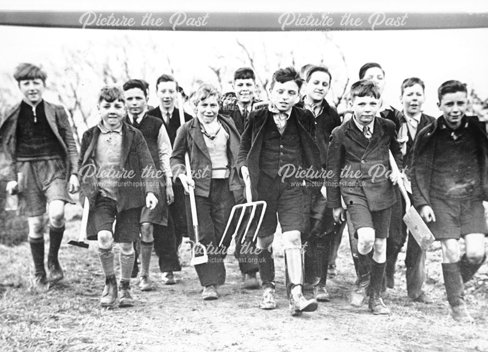 Young boy war evacuees with garden implements