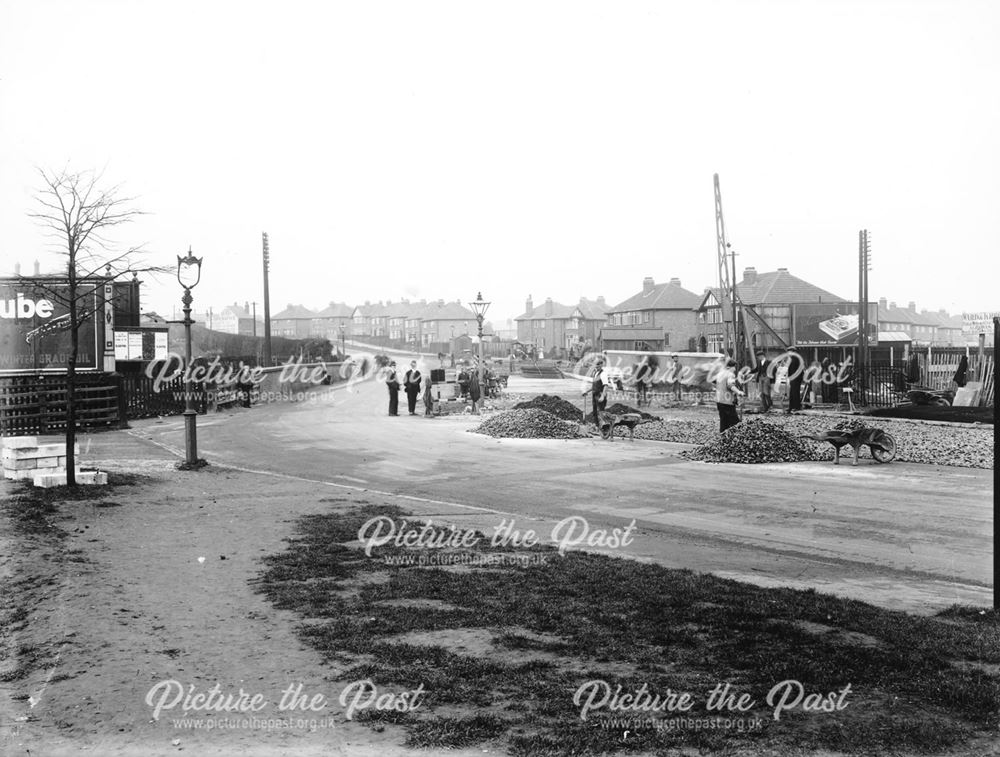 View of workers resurfacing the road, in the area of Pear Tree railway station/railway bridge