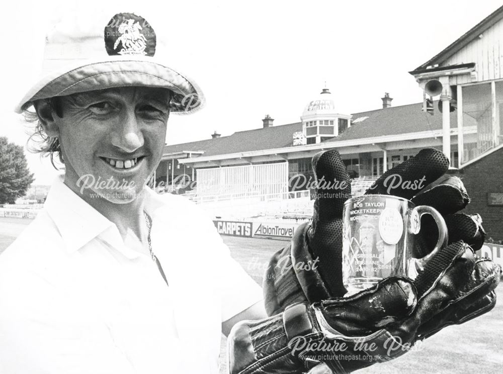 Cricketer for D.C.C.C.,Bob Taylor,holding the tankard for 'world record wicket keeping' 