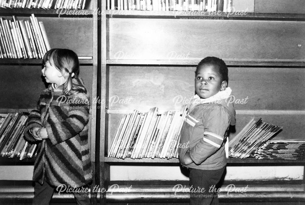 Two children in front of shelves at Pear Tree Library