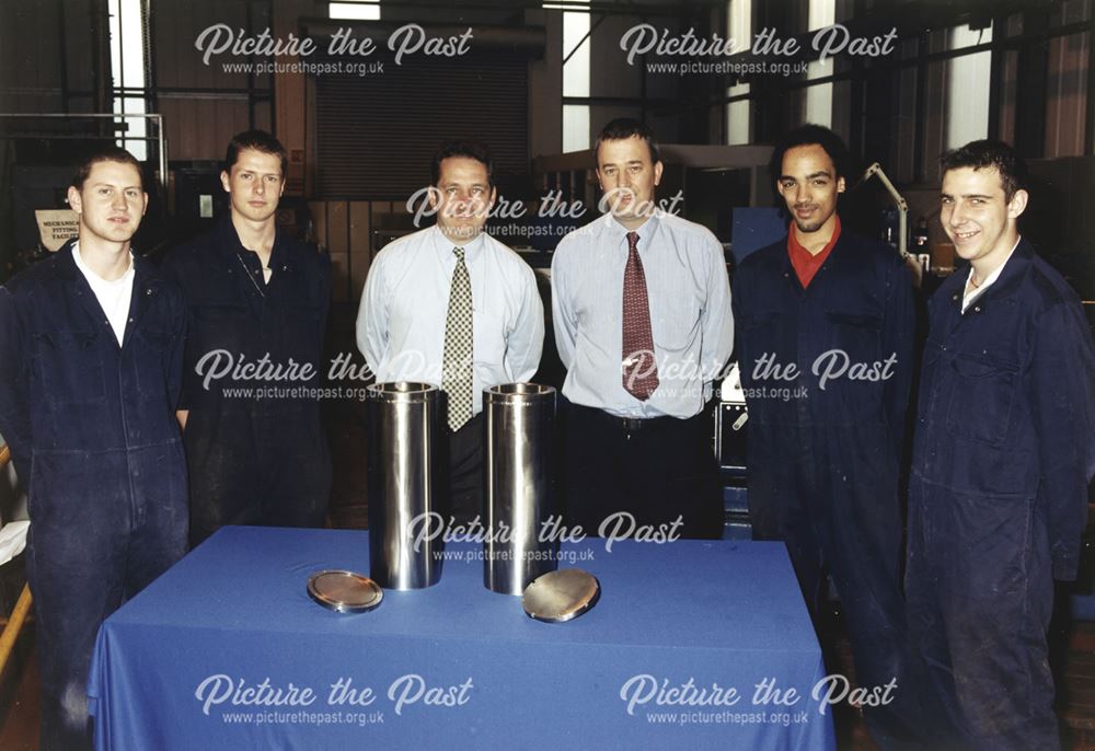 International Combustion Limited - Empty Time Capsules surrounded by workers and managers.