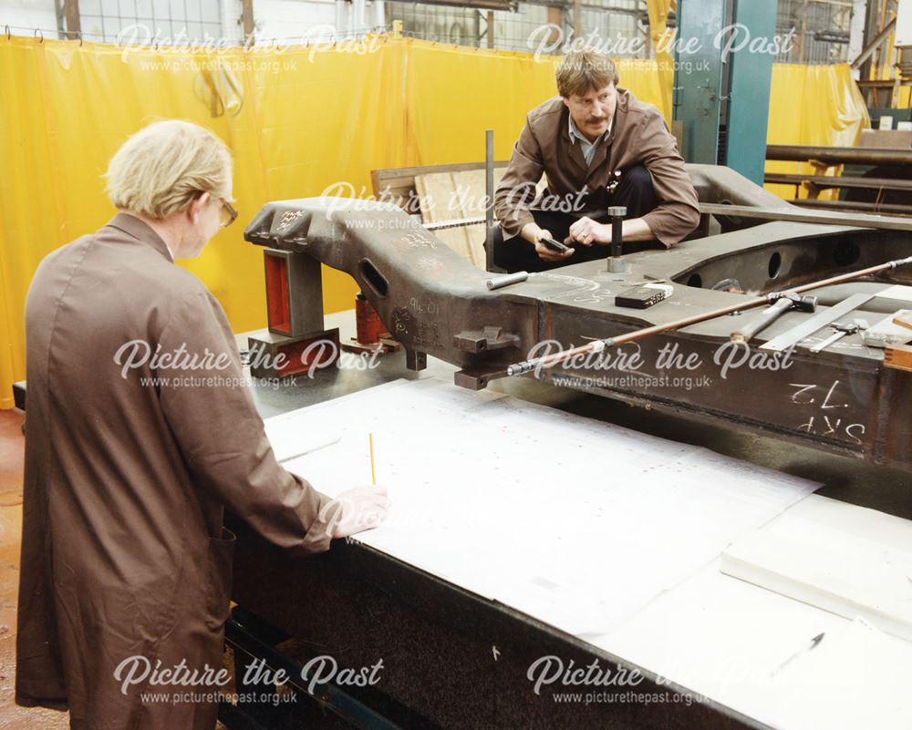 International Combustion Limited - Two employees measuring and checking a component, working from dr